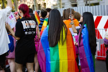 Madrid, İspanya 7 Haziran 2022 Sırtında LGBT gökkuşağı bayrağı taşıyan bir kız geçit, yürüyüş, festival, gösteri. İnsanlar Gurur Ayı 'nı kutluyor. Lezbiyenler, geyler, biseksüeller, transseksüeller, homoseksüeller.. 