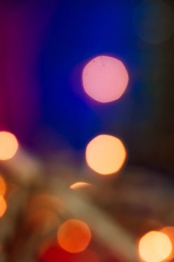 Soyut, koyu mavi arka plan, bulanık kırmızı, sarı çelenk ışıkları. Bulanık fotoğraf. Bayram kış tatili. Yılbaşı ağacı, telefon masaüstü için yeni yıl arkaplanı. 