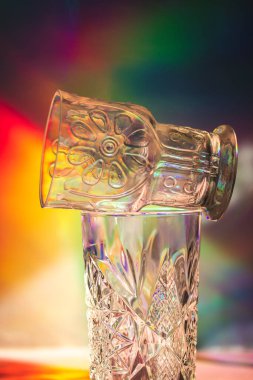 Çok renkli bir arka plan üzerinde bir gölge oluşturan bir gözlük. 90 'lardan kalma nostaljik içecek takımı. Retro natürmort hayat, canlı yüzeye karşı parti dekorasyonu