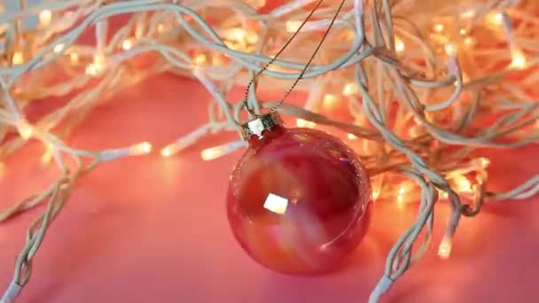 Oranje Glanzend Glas Nieuwjaarsbal Tussen Witte Led Bloemenslingers Nieuwjaar Kerstfeest — Stockvideo