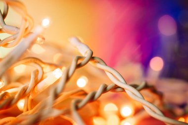 Karmaşık beyaz kablolar LED çelenk Noel ağacı için yumuşak odak. Yeni yıl 2024 ev dekorasyonu. Parlak sarı arka planda sıcak ışıklar. Kutlama için dekore edilmiş evin soyut ayrıntıları.