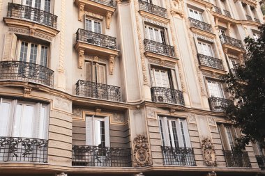 Madrid, İspanya. 1 Aralık 2023 Klasik konut tipi bej bina cephesi, şehir caddesinde balkon. Şehir evleri parçalanmış. İspanyol mimarisi.