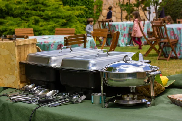Outdoor kitchen equipment. Preparing food on a barbecue party. Food tray with kitchen utensils, bowls, pots and pans. Backyard banquet. Barbecue party