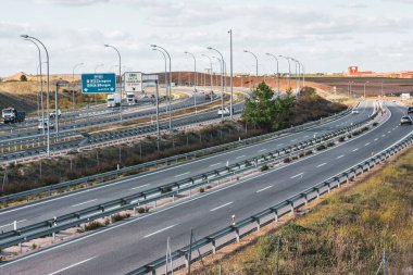 Madrid İspanya 15 Nisan 2023 Asphalted yolu, otoyol uzak bir mesafede, ülke manzarası arabayla seyahat ediyor. Birçok şeridi olan bir otoban Araç trafiği