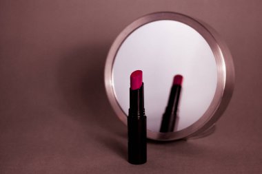 Kadın makyaj masası. Yuvarlak aynaya yansıyan kırmızı ruj. Kozmetik hala hayat. Dekoratif kozmetik örneği. Minimalizm güzellik teması.