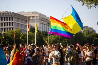 Madrid, İspanya. 3 Temmuz 2022. Gurur Ayı 'nda birçok insan, gençler eğleniyor. Eşcinsel geçit töreni festivali. LGBT sembolleri, gökkuşağı bayrağı ve Ukrayna bayrakları.