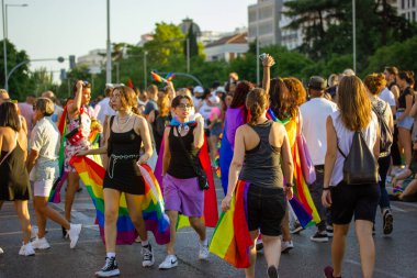 Madrid, İspanya. 3 Temmuz 2022 'de bir grup genç gay geçit töreninde dışarıda eğleniyor. LGBT gökkuşağı bayrakları. Yaz Festivali neşesi. 