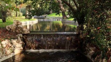 Su akışı, yapay nehirde akış, ilkbaharda akıntı, yaz parkı, park. Ağaçlar ve yeşil çimenler. Huzur, doğa konseptiyle uyum. 