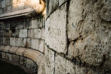 Eski bir bina, duvarları olan bir kale. Antika bina. Gri taş yüzeyin arka planı ve dokusu. Makro fotoğraf perspektifte duvarı güçlendirir.
