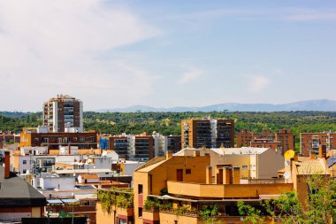 Madrid, İspanya. 1 Temmuz 2023. Yüksek binaların çatıları manzaralı. İspanyol başkenti mahallesi. Tipik mimari ve dağ manzarası. 