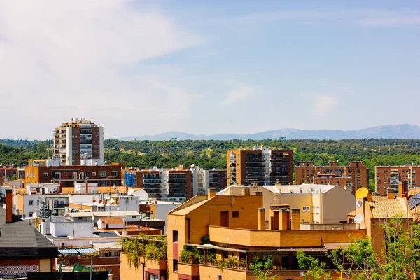 Madrid, İspanya. 1 Temmuz 2023. Yüksek binaların çatıları manzaralı. İspanyol başkenti mahallesi. Tipik mimari ve dağ manzarası. 