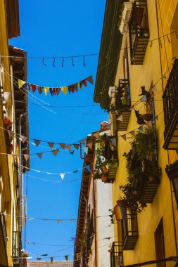 Madrid, İspanya. Mayıs 12023 Avrupa şehrinin eski caddesi güneşli bir günde parti için renkli bayraklarla süslenmiş.