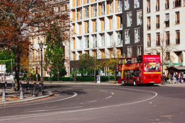 Berlin, Almanya. 1 Ekim 2023 Asphalted şehir sokağı turistik geziler için arabalara ve kırmızı turist otobüsüne dönüşüyor. Modern binalar.