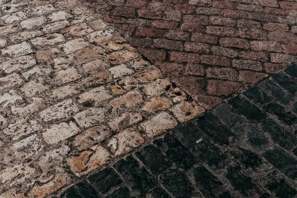Antique weathered stone road. Granite cobblestone pavement texture and pattern. Abstract brown grey stones vintage background. Old town streets.