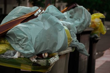 Çöp bidonları ağzına kadar çöp dolu. Çöp tenekeleriyle dolu plastik torbalar. Geri dönüşüm kutusundaki organik atık. Ayrı atık, ekoloji, kirlilik