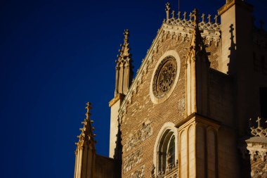 Madrid, İspanya. 1 Mayıs 2024 İspanya 'nın başkentinde mavi gökyüzüne karşı San Jeronimo Roma Katolik Kilisesi' nin taş cephesi. Eski bir simge.. 