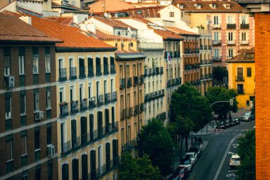 Madrid, İspanya. 1 Mayıs 2024 Avrupa 'da bir caddede eski evleri olan güzel bir şehir manzarası perspektif olarak parlak renkli binalar ön plana çıkıyor