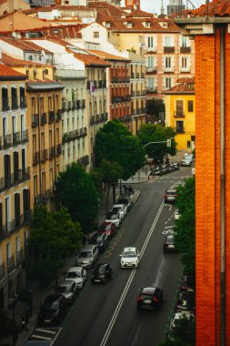 Madrid, İspanya. 1 Mayıs 2024 Avrupa 'da bir caddede eski evleri olan güzel bir şehir manzarası perspektif olarak parlak renkli binalar ön plana çıkıyor