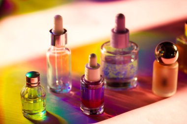 Renkli gökkuşağı arka planında saydam plastik pipo şişeleri. Yüz ve vücut masajı ürünleri. Nemlendirici yüz temizleyici. Masada kozmetik seti. Güzellik endüstrisi. 