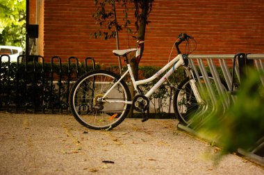 Madrid, İspanya. 17 Mayıs 2024. İki tekerlekli bir bisiklet bir motosiklet parkında park halinde. Bisiklet kiralama servisi. Dışarıdaki ekolojik araç. Şehir manzarası