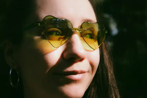 stock image Young happy woman wearing green heart shaped sunglasses closeup portrait. White smiling millennial girl in summertime. Looking away cheerful person. 