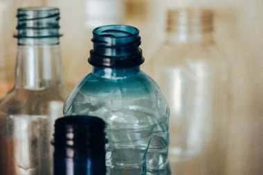 Bulanık zemin üzerinde mavi plastik su şişeleri ve metin için yer var. Plastiği yeniden üretmek için geri dönüştürüyorum. Sıfır atık. 