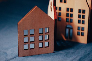 Koyu mavi arka planda eğimli çatıları olan dekoratif ahşap evler. Oyuncak kırsal ahşap kulübeler. Satılık emlak. Konut mülkleri. Ev.