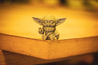 Madrid, İspanya 7 Mayıs 2024 Din Grogu, Star Wars oyuncak kahramanı sarı arka planda izole plastikten yapılmış. Disney serisinden mutlu bebek Yoda. 