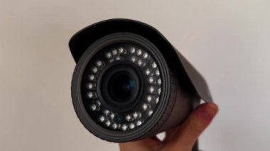 Bir kadının elindeki güvenlik kamerası lensinin yakın çekim görüntüsü. Elektronik. Video kaydedici. CCTV kameraları, izleme, kontrol, koruma, koruma