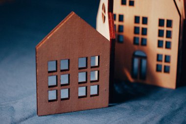 Koyu mavi arka planda eğimli çatıları olan dekoratif ahşap evler. Oyuncak kırsal ahşap kulübeler. Satılık emlak. Konut mülkleri. Ev.