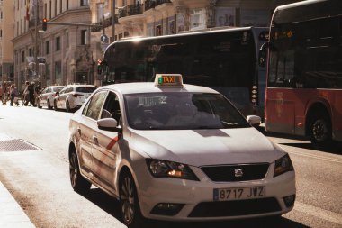 Madrid, İspanya. Güneşli bir günde eski bir şehir caddesinde 1 Temmuz 2024 Beyaz Taksi. İspanya 'nın başkentinde Gran Via Caddesi. Yolcu taşımacılığı.