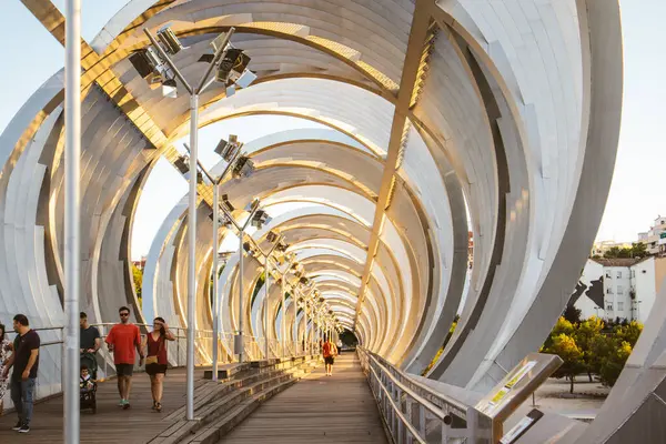 stock image Madrid, Spain. 15 July 2024 Arganzuela bridge tonnel. Architecture of big city. Footbridge tunnel with people on a street. Walkway. Metallic circle.