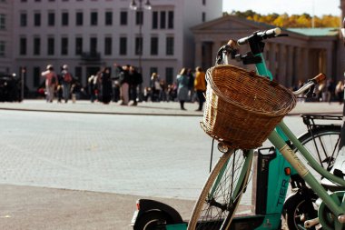 Berlin, Almanya. 1 Ekim 2023 Yeşil Bisiklet Hasır ahşap sepet, gidon ve şehir caddesinde park edilmiş bisiklet çerçevesi. Şehir ulaşımı. 