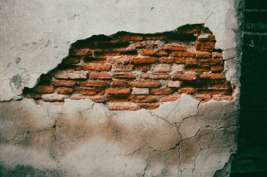 Eski bina cephesi, alçı soyulan, kırmızı tuğladan yapılmış, terk edilmiş bir ev. Malikanenin kaplamasında çatlaklar. Eski çatlamış beton vintage duvar.