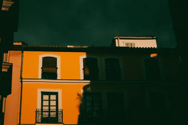 stock image Madrid, Spain July 1 2024 Front view of yellow residential apartment building facade in a shadows at sunset. Typical Historical Spanish architecture.