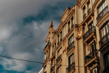 Madrid, İspanya. 1 Temmuz 2024 'te baştan aşağı eski çok katlı bir binanın ön cephesinden güzel bir şekilde alçıyla süslenmiş..