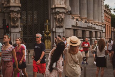 Madrid, İspanya. 20 Temmuz 2024 Bir çok insan bir yaz caddesinde acele ediyor. Eski binalar ve simgeler. İspanyol başkentinde yol geçen turistler. 