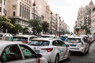 Madrid, İspanya 1 Temmuz 2024 Akşamleyin bir trafik sıkışıklığında bir araba akıntısı. Gran Via caddesinde beyaz taksi. Tarihi binalar.