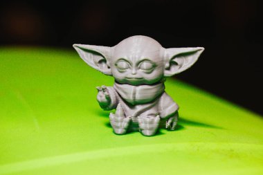 Madrid, Spain 7 May 2024 Din Grogu, Star wars toy hero made of recycling plastic isolated on green background. Happy baby Yoda from Disney series.  clipart