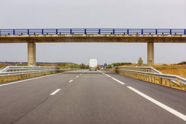 Madrid, İspanya. 1 Ağustos 2023 yaya geçidi, yüksek hızlı bir yol üzerinde köprü, pist, otoyol, devam ediyor. Ufukta bir kamyon var..