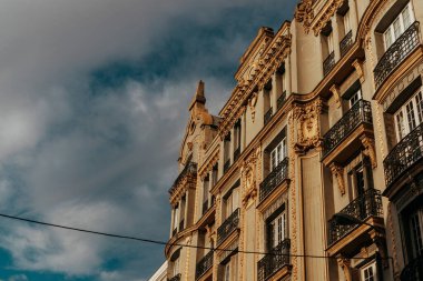 Madrid, İspanya. 1 Temmuz 2024 'te baştan aşağı eski çok katlı bir binanın ön cephesinden güzel bir şekilde alçıyla süslenmiş..