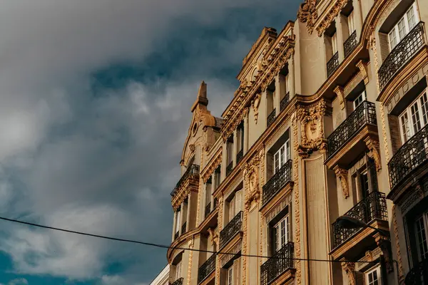 stock image Madrid, Spain. July 1, 2024 View from bottom to top of the facade of a residential old multi-story building beautifully decorated with stucco.