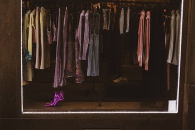 Alışveriş merkezindeki modern moda mağazasının önünde. Pencerenin önünde kadın kıyafetleri mağazası var. Pembe topuklu tulumlar satıyorum.