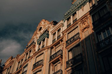 Madrid, İspanya. 1 Temmuz 2024 'te baştan aşağı eski çok katlı bir binanın ön cephesinden güzel bir şekilde alçıyla süslenmiş..