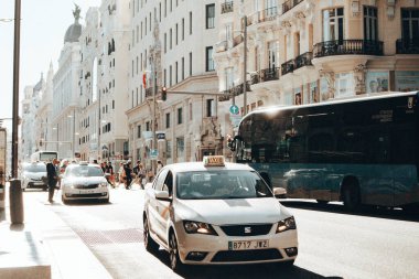 Madrid, İspanya. Güneşli bir günde eski bir şehir caddesinde 1 Temmuz 2024 Beyaz Taksi. İspanya 'nın başkentinde Gran Via Caddesi. Yolcu taşımacılığı.