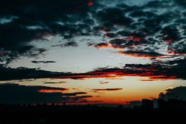 Alacakaranlıkta karanlık renkli gökyüzü. Akşam bulutları batan güneşin son sıcak ışıkları güneş ışığı ve turuncu ve koyu mavi kontrast bulutlarıyla dolu.