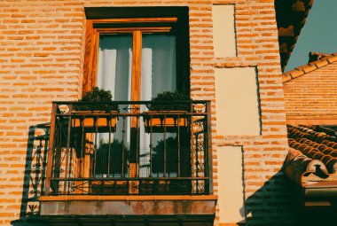 Güneşli ışıkta koyu mavi gökyüzüne karşı eski turuncu bir bina. Sinema filtresi. Evin dış tarafında pencere ve balkon manzaralı bir daire.. 