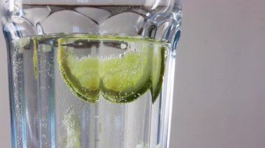 Temiz su, bir dilim limon ya da yeşil kireç ve temiz cam bir şişede hava kabarcıkları. Yumuşak karbonatlı içecek, maden suyu. Deniz aygırı suyu.