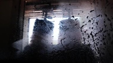 Araba yıkamacıda içeriden iç mekan görüntüsü. Arabaların basınç altında fırçayla yıkandığı tüneller. Otomotiv sektörü.