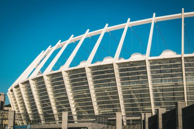 Kyiv, Ukrayna. 1 Ağustos 2024 Ukrayna 'nın başkentindeki Olimpiysky futbol stadyumunun dışı. Mavi gökyüzüne karşı modern beyaz bir bina..